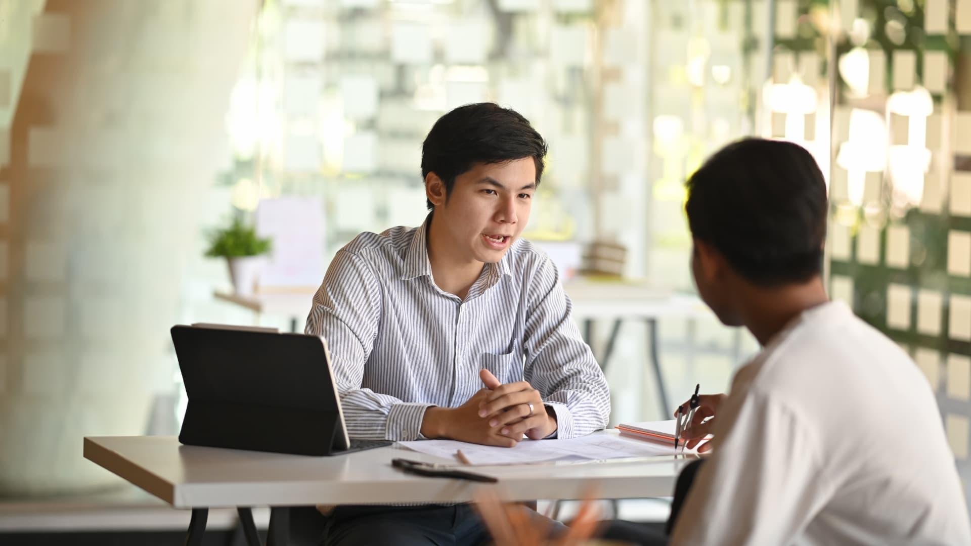 A clinician sitting beside a patient, reviewing results together on a tablet